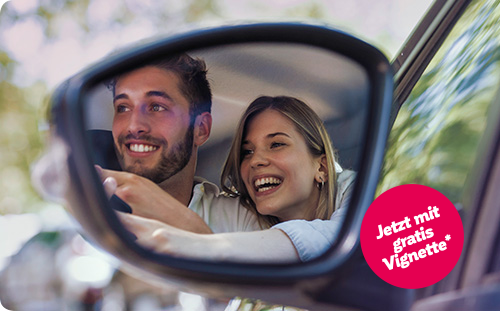 Mann sitzt in seinem neuen Auto und lächelt